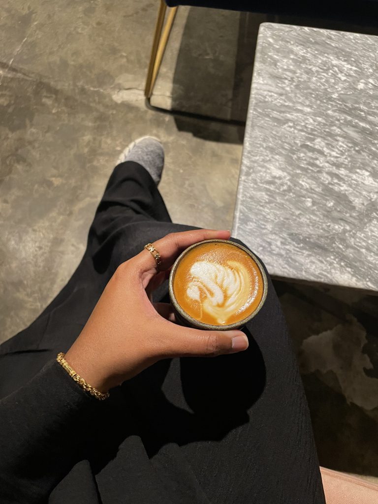 blogger holding coffee in cafe in saudi arabia