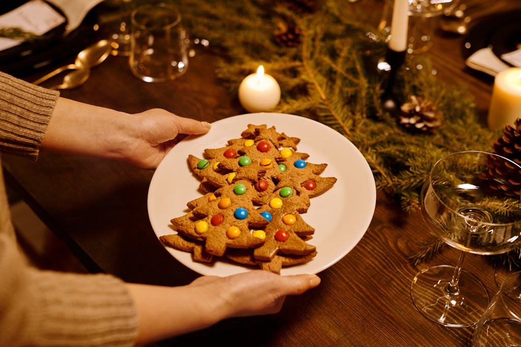 Christmas tree cookies on a decorated table with festive lights and candles.