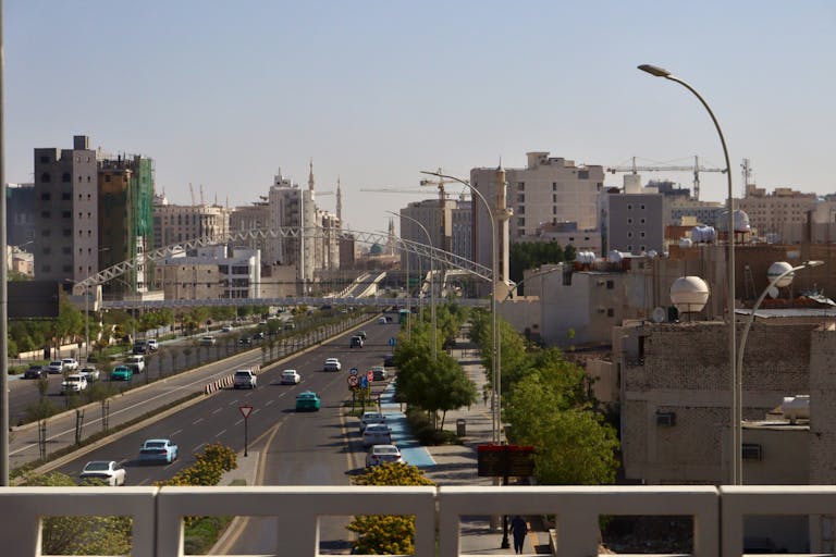 Cityscape of Riyadh with busy streets and modern skyscrapers on a sunny day.