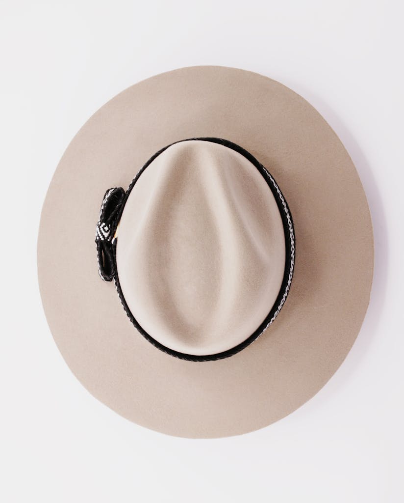 Top view of a stylish beige Panama hat on a pristine white background, showcasing elegance.
